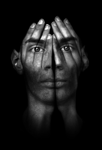 Black and white photo of a teen with silhouette of hands over face